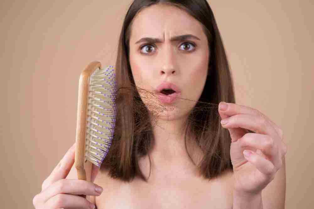 Concerned woman with fallen hair in brush.jpg