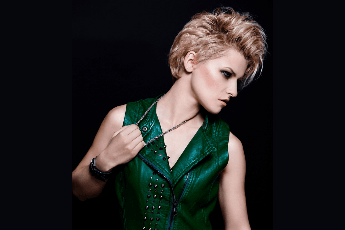 Short blonde rock-and-roll hairstyle in a green vest.